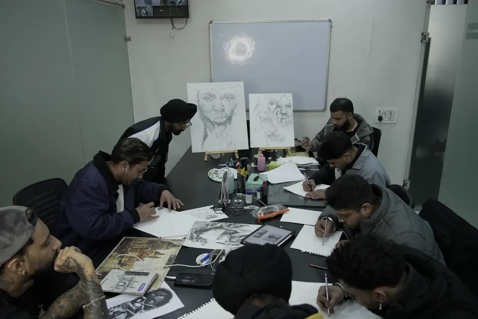 Students drawing at the bench during a class at the Kamz Inkzone Academy